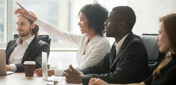woman raising hand to ask question at team training
